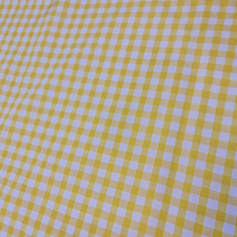 May include: Yellow and white gingham fabric with a checkered pattern.