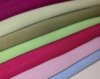 Puede incluir: Conjunto de seis muestras de tela apiladas en varios colores, incluyendo morado, verde, verde claro, rosa y azul.