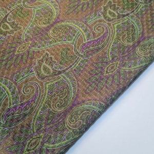 Peut inclure: Un tissu à motif paisley dans des tons de brun, vert et violet. Le tissu a un léger chatoiement.