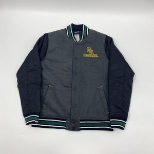Op de afbeelding: Een grijze en zwarte Baylor Bears varsity jas. De jas heeft een grijze body met zwarte mouwen, een knoopsluiting en het Baylor-logo in goud. De kraag en manchetten hebben groen-witte strepen.