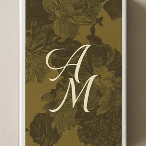 May include: A rectangular box with a floral design in shades of olive green and cream. The design features a pattern of roses and other flowers. The letters "A" and "M" are in a cream-colored script font, centered on the box.