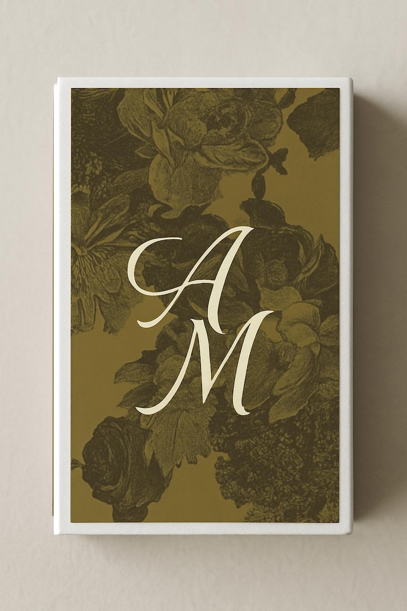 May include: A rectangular box with a floral design in shades of olive green and cream. The design features a pattern of roses and other flowers. The letters "A" and "M" are in a cream-colored script font, centered on the box.