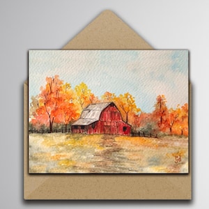 May include: A watercolor painting of a red barn situated in a field during autumn, surrounded by trees with orange and yellow foliage under a pale blue sky. The artwork is displayed inside a brown paper envelope with a triangular flap.