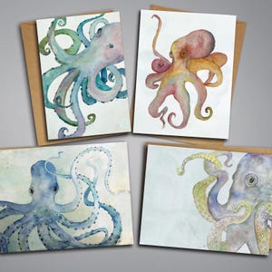 May include: Four greeting cards featuring watercolor illustrations of octopuses. One card shows a blue and green octopus, another a pink and orange octopus, a third a deep blue octopus, and the fourth a grey and yellow octopus on brown envelopes.