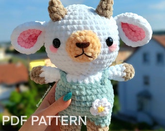 May include: A crocheted white goat amigurumi toy with brown horns, pink ears, and a light blue crocheted outfit. The toy is holding a white flower with a yellow center. The text "PDF PATTERN ONLY" is visible in the image.
