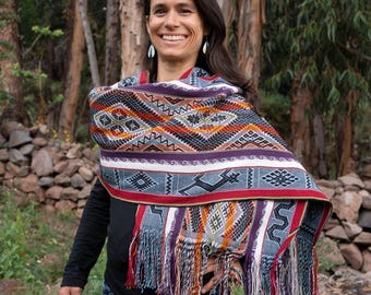 Chal peruano de alpaca: animales sagrados tejidos a mano, tonos coloridos, bufanda para ceremonias andinas.