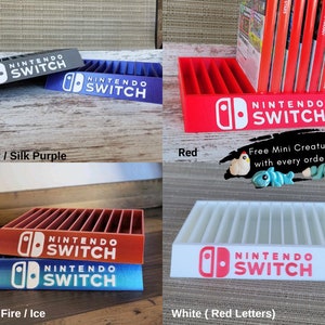 May include: A collection of Nintendo Switch game cartridge holders in various colors, including gray, purple, red, orange, blue, and white. Each holder features the Nintendo Switch logo and is designed to organize game cartridges. The image also includes the text "Free Mini Creature with every order!"