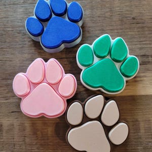 Peut inclure: Quatre emporte-pièces en forme de patte, un bleu, un vert, un rose et un beige.