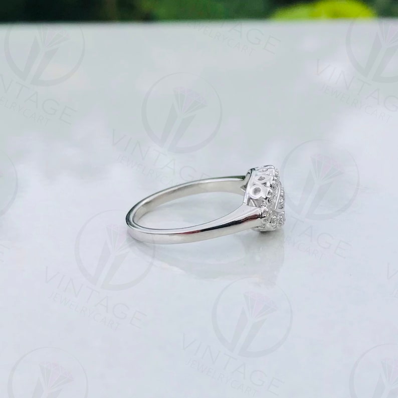 May include: A silver ring with a clear stone set in a decorative, filigree design.