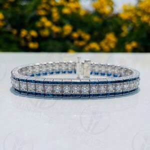 May include: A silver bracelet with a row of square-cut diamonds and a row of blue sapphires.