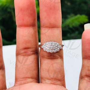 May include: A silver ring with a cluster of small diamonds set in a leaf-shaped design.