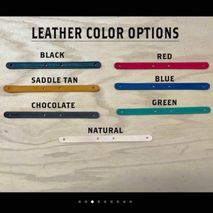 Puede incluir: Una muestra de siete tiras de cuero en varios colores etiquetadas como LEATHER COLOR OPTIONS. Los colores incluyen negro, rojo, marr&oacute;n cuero, azul, chocolate, verde y natural. Cada tira es larga, estrecha y tiene tres peque&ntilde;os orificios.