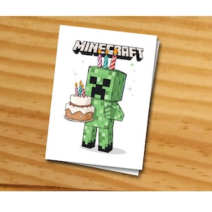 May include: A green Minecraft Creeper character holding a birthday cake with candles. The cake is decorated with white icing and sprinkles. The Creeper has a green face with a black mouth and eyes. The text "MINECRAFT" is above the Creeper.