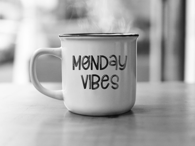 Pu&ograve; includere: Tazza in ceramica bianca con bordo nero e il testo "Monday Vibes" in un carattere nero stilizzato.