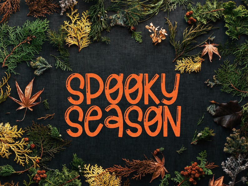 Pu&ograve; includere: Uno sfondo scuro con foglie autunnali che circondano il testo "Spooky Season" in arancione.