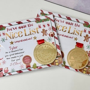May include: A gold medal with a red ribbon and a Christmas-themed design. The medal says "North Pole Approved Nice List" and is presented with a card that says "You've made the Nice List Congratulations!" and "Tyler As a reward for you good behaviour this medal is just for you S.Claus".