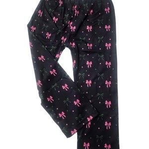 May include: Black pants with a pink bow pattern.