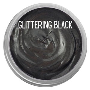 Peut inclure: Un r&eacute;cipient circulaire rempli d'une substance &eacute;paisse et visqueuse de couleur gris anthracite m&eacute;tallique avec une finition scintillante. Le texte GLITTERING BLACK est imprim&eacute; en lettres capitales blanches sans empattement au centre.