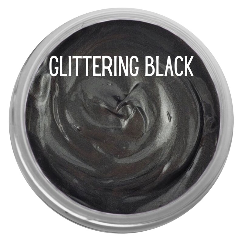 Peut inclure: Un r&eacute;cipient circulaire rempli d'une substance &eacute;paisse et visqueuse de couleur gris anthracite m&eacute;tallique avec une finition scintillante. Le texte GLITTERING BLACK est imprim&eacute; en lettres capitales blanches sans empattement au centre.