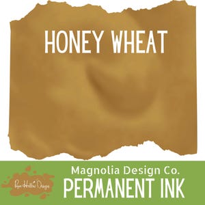 May include: A rectangular swatch of Honey Wheat colored permanent ink with a torn paper edge effect. The text HONEY WHEAT is printed in white at the top. A green bar at the bottom displays the text Magnolia Design Co. PERMANENT INK.