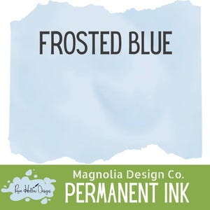May include: A light blue watercolor background with the words "FROSTED BLUE" in bold black letters. Below, a green banner displays "Magnolia Design Co. PERMANENT INK". The design suggests a product related to crafting or art supplies.