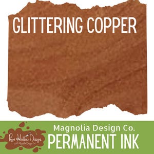 May include: A swatch of metallic copper colored permanent ink with a textured appearance. The text GLITTERING COPPER is printed in white at the top. The bottom green section features the text Magnolia Design Co. PERMANENT INK.