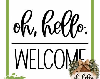 May include: A reusable silkscreen stencil featuring the black text "oh, hello." in a cursive script above a horizontal line and the word "WELCOME" in a bold sans-serif font. A small circular wooden sign with a bow and greenery is shown.