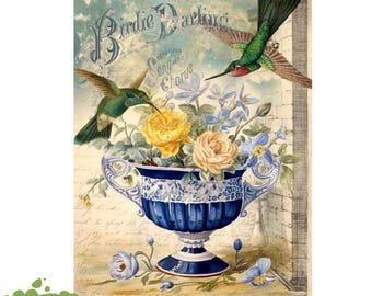 May include: A decorative rub-on transfer sheet titled Birdie Darling featuring two hummingbirds, one green and one with a red throat, hovering over a blue and white urn filled with yellow and cream roses and blue flowers against a script background.