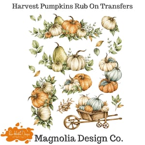 May include: A sheet of Harvest Pumpkins Rub On Transfers by Magnolia Design Co. featuring watercolor-style illustrations of orange, white, and green pumpkins, gourds, and autumn leaves, including a wooden wheelbarrow filled with pumpkins.