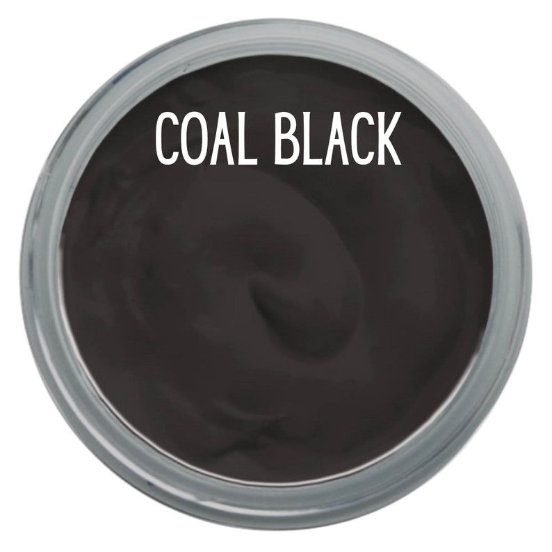 K&ouml;nnte beinhalten: Ein runder Beh&auml;lter gef&uuml;llt mit einer glatten, kohleschwarzen Substanz. Der Text COAL BLACK ist in wei&szlig;en Gro&szlig;buchstaben in der oberen Mitte des dunklen Materials aufgedruckt, das eine dicke, cremige und gleichm&auml;&szlig;ige Konsistenz aufweist.