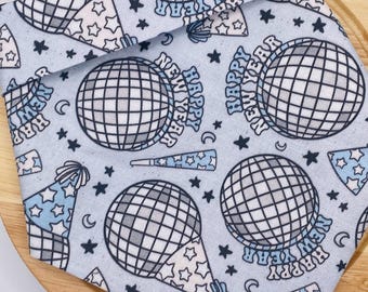 May include: A blue fabric with a repeating pattern of disco balls, party hats, and stars. The text "Happy New Year" is repeated throughout the pattern.