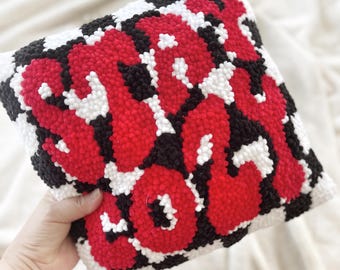 Cojín acogedor con detalles de terciopelo a cuadros rojos y negros