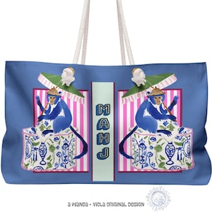 May include: Blue tote bag featuring a whimsical design with blue monkeys, parasols, and decorative boxes. The bag has white rope handles and the word "MAHJ" in a vertical column. The design is set against a blue background with pink and white stripes.