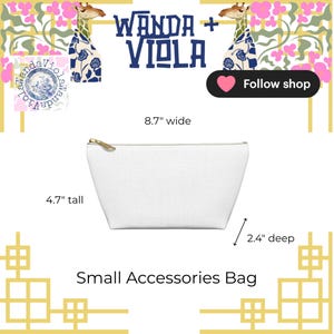 May include: A white small accessories bag with a gold zipper, 8.7 inches wide, 4.7 inches tall, and 2.4 inches deep. The bag has the text "Wanda + Viola" and "Small Accessories Bag". The background has giraffe illustrations and floral patterns.