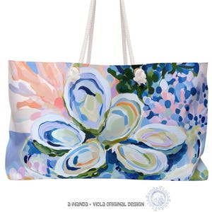 May include: A tote bag featuring a painterly design of oysters on a platter with coral and blue floral accents. The bag has white rope handles and the text "a WANDA + VIOLA ORIGINAL DESIGN" printed in black at the bottom center of the image.