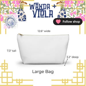 May include: A white large bag with a gold zipper, measuring 12.6 inches wide, 7.3 inches tall, and 3.2 inches deep. The bag has the text "WANDA + VIOLA" and "Large Bag" printed on it. The background features giraffe illustrations.