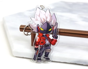 May include: A white-haired character with a black mask and red jacket holding a gun. The character is a keychain charm made of clear acrylic.