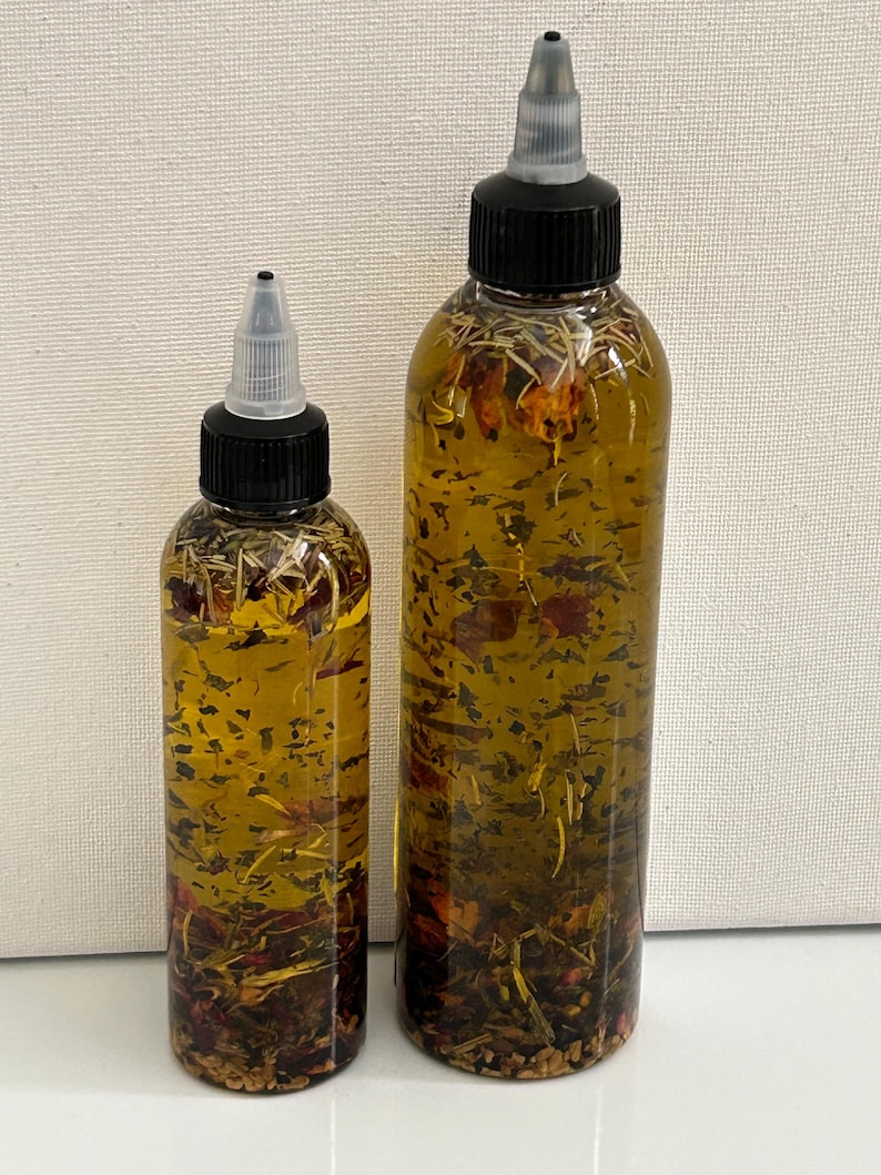 May include: Two clear glass bottles with black caps and droppers filled with a yellow liquid and dried herbs and flowers.