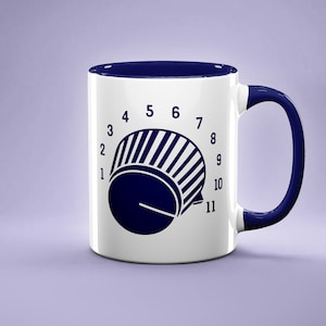 Peut inclure: Une tasse en céramique blanche avec un bord et une poignée bleus. La tasse présente un graphique d'un bouton bleu avec les chiffres de 1 à 11 autour.