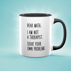 Könnte beinhalten: Eine weiße Keramik-Kaffeetasse mit schwarzem Rand und Henkel. Die Tasse hat einen schwarzen Text mit der Aufschrift "Liebe Mathematik. Ich bin kein Therapeut. Löse deine eigenen Probleme."