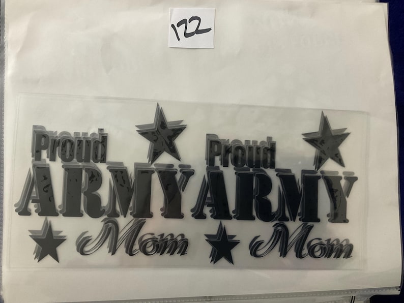 K&ouml;nnte beinhalten: Eine transparente Folie mit dem Schriftzug "Proud ARMY Mom" in dunkler, dreidimensionaler Schrift mit Sternen. Die Nummer "122" ist oben rechts auf einem wei&szlig;en Etikett zu sehen.