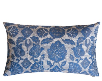 May include: A rectangular decorative pillow with a blue floral pattern on a silver background. The pillow has a soft, textured appearance and is designed for home decor. The floral design includes stylized flowers and leaves.