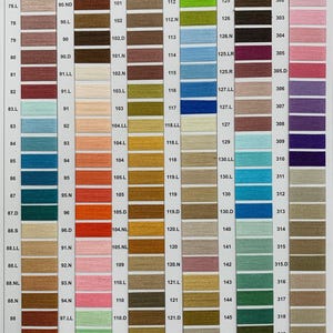 May include: A color chart of embroidery floss with numbered thread colors. The chart is divided into 12 strips, each with a different color range. The colors range from green, brown, yellow, blue, orange, red, pink, and beige.