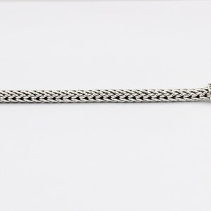 Peut inclure: Un bracelet en argent avec des fermoirs en t&ecirc;te de dragon. Le bracelet est fait d'une cha&icirc;ne tiss&eacute;e.