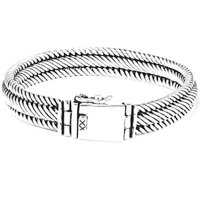 May include: A silver bracelet with a braided design and a clasp closure.