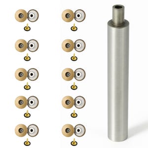 May include: A collection of metal snap fasteners with a cylindrical metal tool. The snap fasteners have a gold-colored cap, a silver-colored ring, and a black base. The cylindrical tool is made of brushed metal.