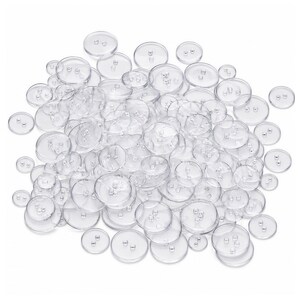 May include: A large collection of round, clear plastic buttons scattered in a pile. Each button features a smooth, transparent surface and two small holes in the centre for sewing attachment. The buttons vary slightly in size and are arranged randomly.