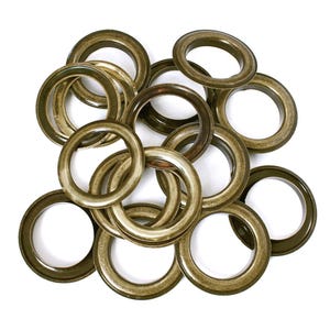 May include: A pile of gold-coloured metal eyelets, used for reinforcing holes in fabric.
