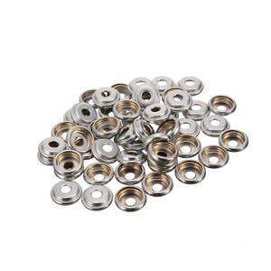 May include: A pile of silver snap fasteners. Each fastener has a circular, flat top with a central hole, and a matching base. The fasteners are made of metal and have a shiny finish. They are scattered on a white background.