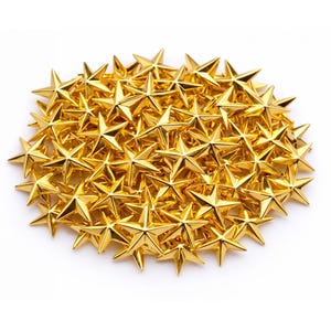 Könnte beinhalten: Eine Ansammlung glänzender, goldfarbener sternförmiger Ornamente. Die Sterne sind dicht beieinander angeordnet und bilden eine dichte, strukturierte Anordnung. Jeder Stern hat fünf Zacken und eine reflektierende Oberfläche, die das Licht einfängt. Diese dekorativen Sterne sind ideal für Bastelarbeiten und Verzierungen.